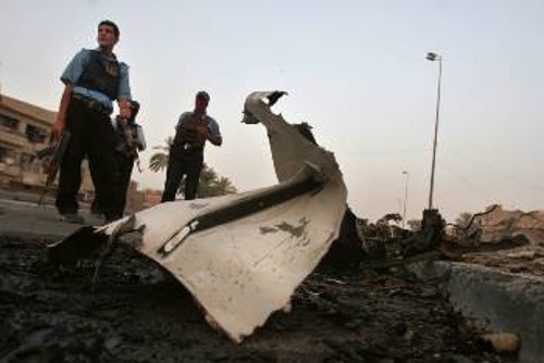 Ιρακινοί αστυνομικοί «περιφρουρούν» ό,τι απόμεινε από ένα ανατιναγμένο από βόμβα αυτοκίνητο 