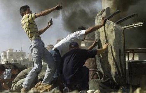 Νεαροί Παλαιστίνιοι προσπαθούν να προστατευτούν από τις σφαίρες των Ισραηλινών