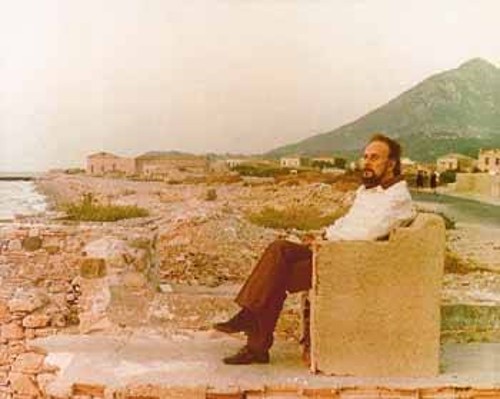 Ο Γ. Ρίτσος καθισμένος σε πέτρινο «θρόνο» αγναντεύει τη σαμιώτικη θάλασσα
