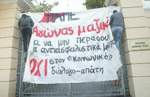 Συνδικαλιστές του ΠΑΜΕ αναρτούν το πανό στην πύλη του υπουργείου Μακεδονίας Θράκης