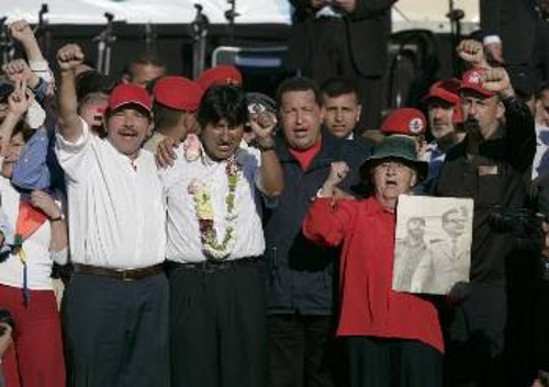 Ορτέγκα, Μοράλες, Τσάβες, Λάγκε στη συνάντηση των λαών. Η διαδηλώτρια με χαρακτηριστική φωτογραφία του Φιντέλ Κάστρο και του δολοφονημένου Χιλιανού προέδρου Σαλβαδόρ Αλιέντε