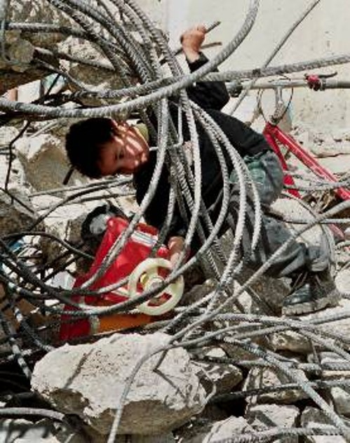 Ο νεαρός Παλαιστίνιος προσπαθεί κάτω από τα ερείπια του σπιτιού που κατέστρεψαν οι ισραηλίτες να πιάσει ένα παιχνίδι του
