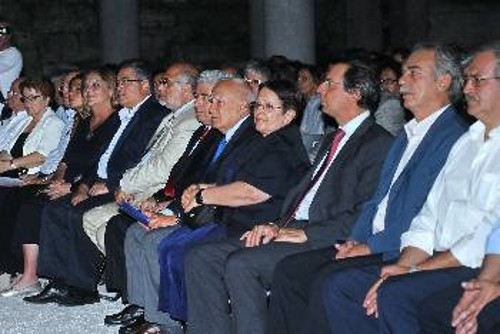 Αριστερά από την Αλέκα Παπαρήγα, όπως βλέπουμε τη φωτογραφία, διακρίνονται κατά σειρά ο Πρόεδρος της Ελληνικής Δημοκρατίας Κάρολος Παπούλιας, ο Πρόεδρος της Κυπριακής Δημοκρατίας Δημήτρης Χριστόφιας και ο πρέσβης της Κύπρου Γ. Γεωργής. Δεξιά ο υπουργός Πολιτισμού Μ.Λιάπης