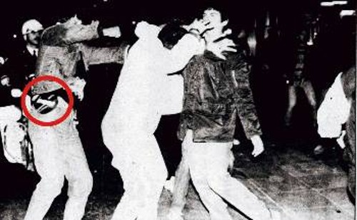 18/11/1985. Ασφαλίτες με πολιτικά χτυπούν φωτορεπόρτερ, παρουσία των ΜΑΤ, στο Πολυτεχνείο, με το περίστροφο του ενός να διακρίνεται περασμένο στη ζώνη του...