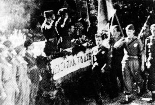 Παρέλαση μαχητών του ΔΣΠ στο χώρο του Αρχηγείου στο Μαίναλο υπό το βλέμμα της ηγεσίας τους. Διακρίνονται ο Στέφανος Γκιουζέλης, αρχηγός της 3ης Μεραρχίας, και ο Βαγγέλης Ρογκάκος, Πολιτικός Επίτροπος