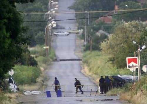 Οι στρατιώτες της ΠΓΔΜ αναζητούν κάλυψη καθώς πίσω από τα αυτοκίνητα στο βάθος βρίσκονται Αλβανοί αυτονομιστές που τους πυροβολούν