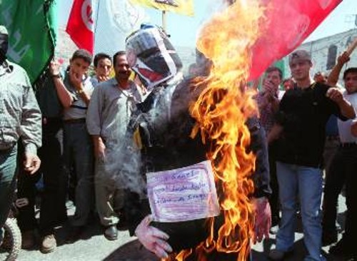 Παλαιστίνιοι διαδηλωτές καίνε ένα ομοίωμα του Α. Σαρόν
