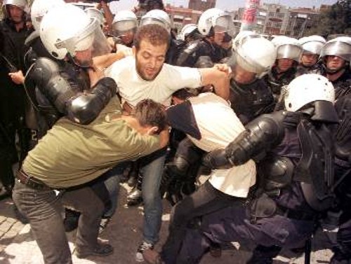 Αστυνομικοί απομακρύνουν διαδηλωτή. «Σφαγέα, φύγε!» φώναζαν εκατοντάδες διαδηλωτές στην Αγκυρα
