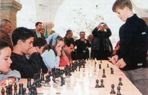 Το παιδί - θαύμα του παγκοσμίου σκακιού, Μάγκνους Κάρλσεν, αντιμετωπίζει σε ηλικία 14 χρόνων (ήδη GM) 25 αντιπάλους συγχρόνως. Αποτέλεσμα; 22 νίκες, 2 ισοπαλίες, 1 ήττα!