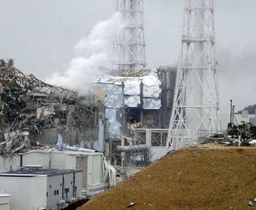 Σε πρώτο πλάνο ο κατεστραμμένος αντιδραστήρας Φουκουσίμα 4. Λίγο πιο πίσω, καπνός αναδύεται από τον επίσης κατεστραμμένο, από έκρηξη μίγματος υδρογόνου - οξυγόνου, Φουκουσίμα 3