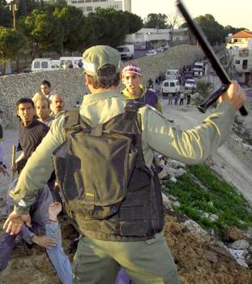 Κραδαίνοντας το κλομπ ο Ισραηλινός στρατιώτης ορμά πάνω σε Παλαιστίνιους νεολαίους, ενώ, την ίδια στιγμή, κλιμακώνονταν οι βομβαρδισμοί των αυτόνομων περιοχών