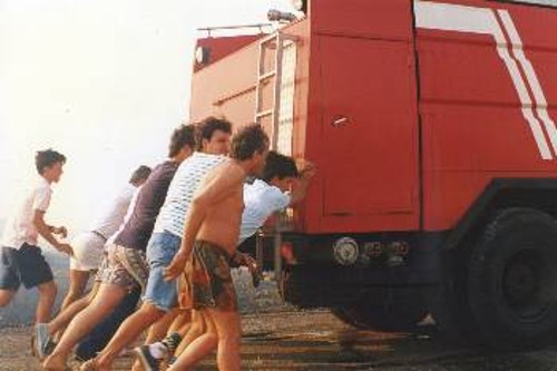 Κάτοικοι σπρώχνουν το χαλασμένο όχημα της Πυροσβεστικής κατά τη διάρκεια πυρκαγιάς στην Ανάβυσσο το 1993. Ιδιες σκηνές αναμένονται και φέτος εξαιτίας της ελλιπούς συντήρησης και της υποχρηματοδότησης