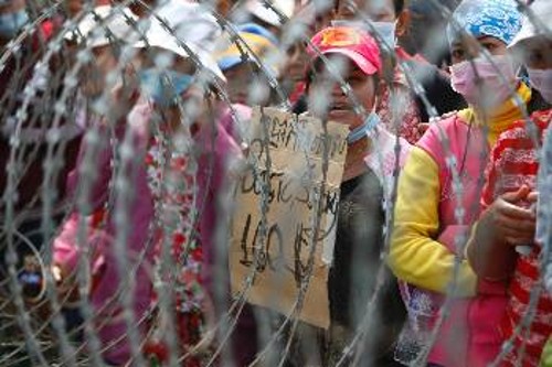 Δεκέμβρης 2013: Εργάτριες από υφαντουργεία διαδηλώνουν στην Πνομ Πενχ για καλύτερα μεροκάματα