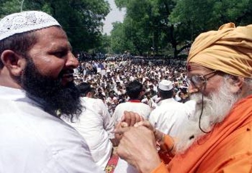 Ενας μουσουλμάνος (αριστερά) κι ένας ινδουιστής κληρικός δίνουν τα χέρια σε διαδήλωση έξω από την Ινδική Βουλή, σε μια καταγγελία της βίας που «σπονσοράρει» η κυβέρνηση Βάτζπαϊ