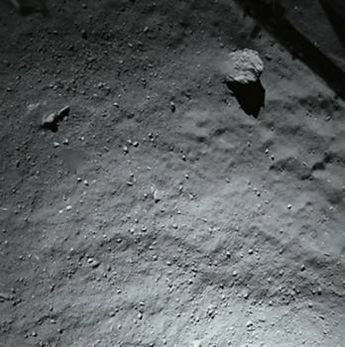 Φωτογραφία της επιφάνειας του Τσουριούμοφ - Γκερασιμένκο που τράβηξε η «Φιλέ» 40 μέτρα πριν ακουμπήσει για πρώτη φορά στο έδαφος. Φαίνονται το σαθρό έδαφος, πέτρες μεγέθους εκατοστών και άλλες μέτρων με το μεγαλύτερο βράχο πάνω δεξιά να έχει μήκος 5 μέτρων. Η σκόνη που βρίσκεται πάνω του δείχνει ότι υπάρχει μετακίνηση, αλλά δεν είναι γνωστό ακόμα αν η σκόνη ανέβηκε σ' αυτόν, ή υποχωρεί