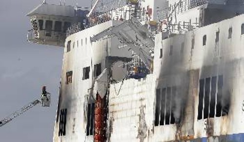 Ιταλοί πυροσβέστες προσπαθούν να σβήσουν τις εστίες της φωτιάς στο πλοίο που έχει ρυμουλκηθεί στο Μπρίντεζι
