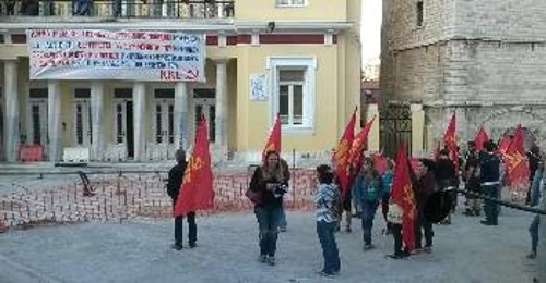 Μέλη του ΚΚΕ και της ΚΝΕ στην Κοζάνη, με φόντο το πανό στο Δημαρχείο για το χτεσινό συλλαλητήριο