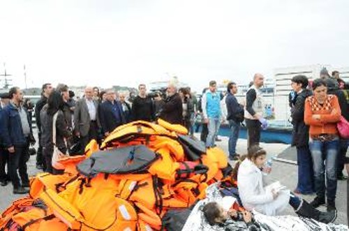 Σωρός από σωσίβια, από τους πάνω από 200 πρόσφυγες που μόλις είχαν αποβιβαστεί στο λιμάνι