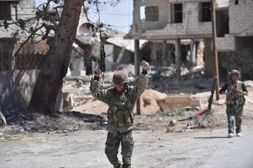 Σύροι στρατιώτες πανηγυρίζουν για την ανακατάληψη της πόλης Καριαταίν, λίγες μέρες πριν τη διεξαγωγή των εκλογών στις 13 Απρίλη