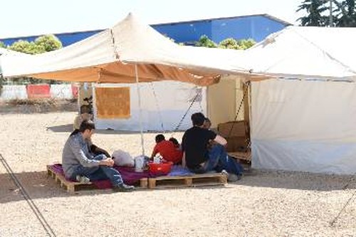 «Καλυμμένοι» από πρόχειρες τέντες, οι πρόσφυγες προσπαθούν να προστατευτούν από τον καυτό ήλιο
