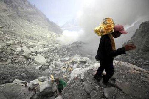 16 Απρίλη 2016: Ινδονήσιοι εργάτες κουβαλούν θείο, βγαίνοντας από κρατήρα ηφαιστείου, στα 9.000 πόδια πάνω από τη θάλασσα, για ένα μεροκάματο 10 δολαρίων. Ετσι πλουτίζουν τα μονοπώλια που κοντράρονται για μια καλή θέση στην περιοχή