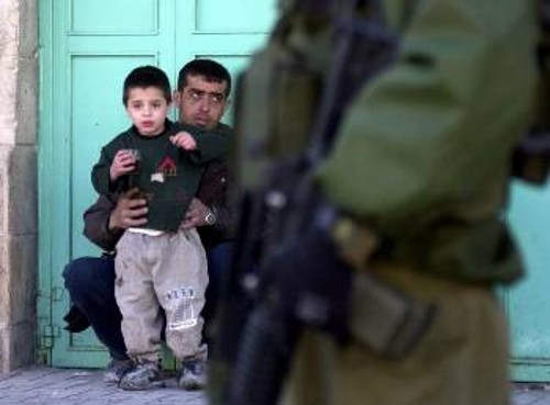 Παλαιστίνιος με το γιο του υποχρεώνεται να γονατίσει, όπως τον διέταξε ο Ισραηλινός στρατιώτης