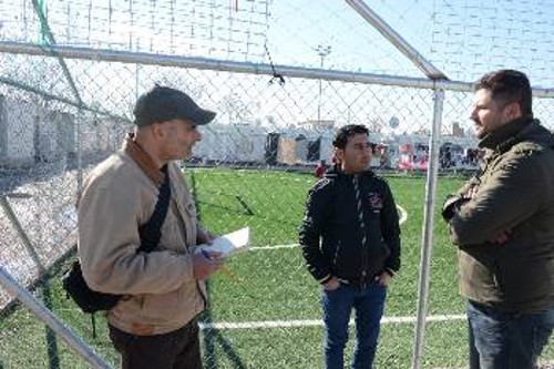 Ο συντάκτης του «Ριζοσπάστη» μιλά με πρόσφυγες στον καταυλισμό του Ελαιώνα