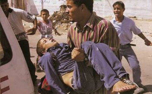 Στην Παλαιστίνη, στη γη της γενοκτονίας, ο πατέρας κρατά στα χέρια του το γιο που δείχνει ανήμπορος να αναπνεύσει. Η απόγνωση κι η φρίκη αποτυπωμένες στα πρόσωπα όλων
