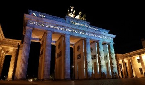 Η φωταγωγημένη Πύλη του Βρανδεμβούργου στο Βερολίνο αναγγέλλει την έναρξη της γερμανικής προεδρίας της ΕΕ