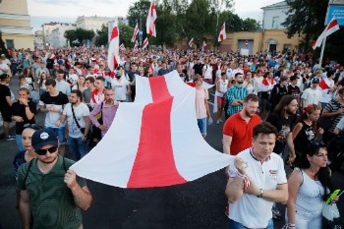 Οι αντιπολιτευόμενοι στον Λουκασένκο με την παλιά σημαία της χώρας, που χρησιμοποιήθηκε και την περίοδο της γερμανικής κατοχής