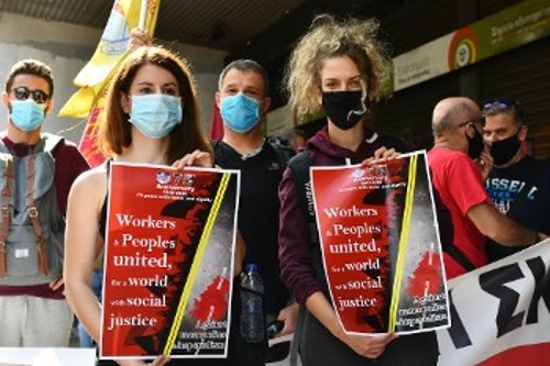 Διαδηλωτές από τη χτεσινή συγκέντρωση στο υπουργείο Εργασίας, με την αφίσα για τα 75χρονα της ΠΣΟ