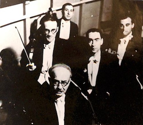 Ο Σκαλκώτας με διακεκριμένους συναδέλφους του στην Ορχήστρα της Λυρικής. Μπροστά ο «θρυλικός» κοντραμπασίστας Ιωάννης Π. Τζουμάνης (1888 - 1957), πίσω του αριστερά ο Σκαλκώτας και δίπλα του ο κορνίστας Ιωάννης Κούρκουλος (1914 - 1993). Πίσω επίσης κορνίστες, δεξιά ο Γεώργιος Τσιριγώτης και αριστερά ο Σπυρίδων Λέκκας ή «Γουλιελμής» (φωτογρ. Αρχείου Χρήστου Ηλ. Κολοβού)