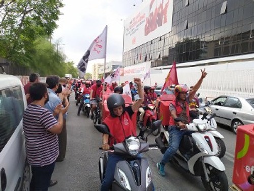 Οι εργαζόμενοι καταχειροκροτούμενοι περνούν μπροστά από τα γραφεία του ΚΚΕ στον Περισσό