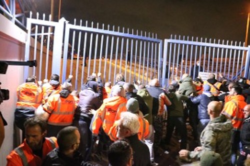 Οι λιμενεργάτες ξηλώνουν την πύλη για να φτάσουν στα κεντρικά γραφεία της εταιρείας