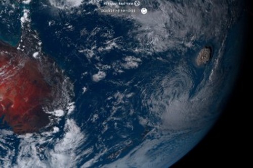 Δεξιά σε αυτήν τη δορυφορική φωτογραφία φαίνεται το μανιτάρι της τεράστιας ηφαιστειακής έκρηξης στα νησιά Τόνγκα, ενώ αριστερά διακρίνεται με κοκκινωπό χρώμα η ανατολική πλευρά της Αυστραλίας