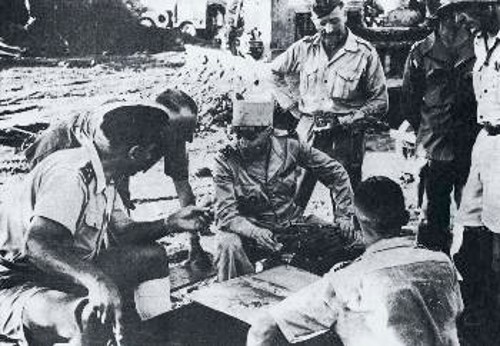 Το επιτελείο των Γάλλων αποικιοκρατών: Ο στρατηγός Κονί (αριστερά), διοικητής των δυνάμεων του Τονκίν, συσκέπτεται με το στρατηγό Ναβάρ, αριστράτηγο των Γάλλων στην Ινδοκίνα (με το πηλίκιο) στο Ντιέν Μπιέν Φου. Ο Ντε Καστρί (διοικητής της φρουράς που αιχμαλωτίστηκε όταν κατελήφθη η τοποθεσία) είναι ανάμεσα στους δύο