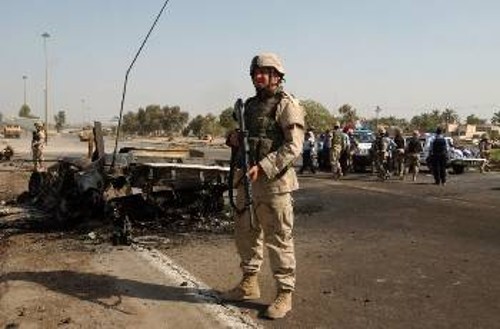 Κατοχικός στρατιώτης κλείνει την περιοχή που χτυπήθηκε αυτοκινητοπομπή από την ιρακινή αντίσταση