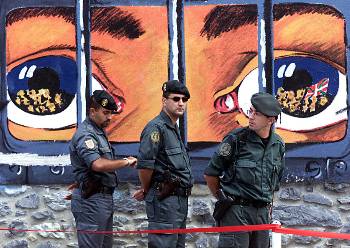 Τρεις στρατιωτικοί στέκονται μπροστά σε βασκικό γκράφιτι, λίγο μετά το θάνατο του Μουχίκα, που πέθανε όταν εξερράγη βόμβα στο αυτοκίνητό του, στις 14 Ιούλη