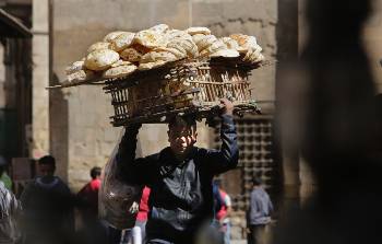 Το χαρακτηριστικό ψωμί που μεταφέρει ο νεαρός γίνεται όλο και πιο ...δύσκολο για μεγάλο τμήμα του αιγυπτιακού λαού