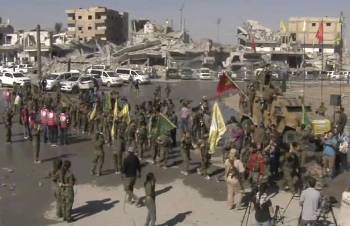 Πανηγυρισμοί μαχητριών των δυνάμεων SDF στη Ράκα με φόντο όγκους ερειπίων...