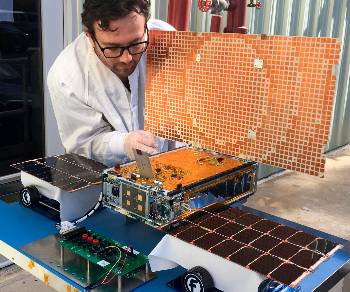 Τεχνικός της NASA ελέγχει έναν από τους μικροδορυφόρους «MarCO» ρίχνοντας ηλιακό φως πάνω στο φωτοβολταϊκό πάνελ του