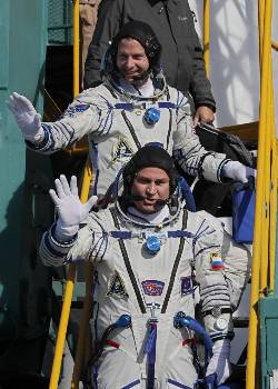 Ο Ρώσος κοσμοναύτης Αλεξέι Οβτσίνιν (μπροστά) και ο Αμερικανός αστροναύτης Νικ Χέιγκ, τη στιγμή που χαιρετούν τους παριστάμενους λίγο πριν από την επιβίβασή τους στον πύραυλο «Σογιούζ-FG»