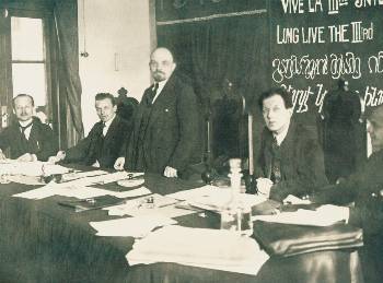 Στο Προεδρείο του 1ου Συνεδρίου, από αριστερά: Γκούσταβ Κλίνγκερ, Ούγκο Εμπερλαϊν, Β.Ι. Λένιν, Φριτς Πλάτεν.