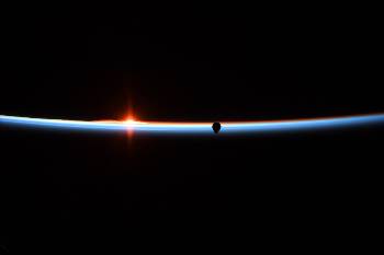 Η Αμερικανίδα αστροναύτης Αν Μακλέιν τράβηξε αυτήν την όμορφη φωτογραφία της ανατολής του Ηλιου, με τη σκιά του «Crew Dragon», που πλησιάζει, να διαγράφεται καθαρά στη λεπτή φωτεινή «φλούδα» της γήινης ατμόσφαιρας