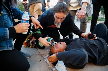 Διαδηλωτής κείτεται στο έδαφος μετά την κατάρρευσή του εξαιτίας εισπνοής δακρυγόνων, κατά τη διάρκεια διαδήλωσης στο Σεντ Πολ της Μινεσότα των ΗΠΑ