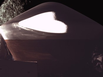 Η κάψουλα επιστροφής του δείγματος εδάφους του Μπενού στη Γη, προσαρμοσμένη πάνω στο «OSIRIS - REx», όπως φωτογραφήθηκε από κάμερα της ίδιας της διαστημοσυσκευής, με τον Μπενού να φαίνεται στο βάθος
