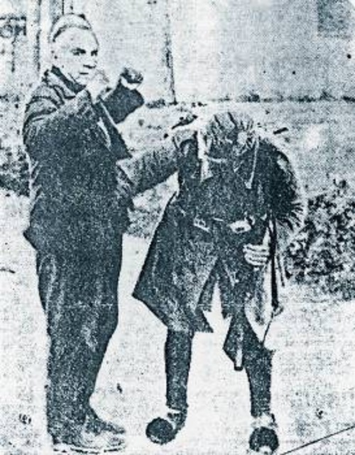 Ενας από τους άνδρες των ταγμάτων ασφαλείας του Ι. Ράλλη, υποβάλλει σε σωματική έρευνα για λογαριασμό των Γερμανών, Ελληνα πολίτη στην Αθήνα, αφού πρώτα τον διέταξε «ψηλά τα χέρια»